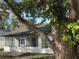 White house exterior with screened porch and brown roof, partially shaded by large tree at 1562 Lawndale Cir, Winter Park, FL 32792