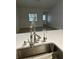 Close-up of a stainless steel kitchen sink and faucet with a modern white countertop at 1562 Lawndale Cir, Winter Park, FL 32792