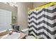 Bathroom with grey and yellow chevron shower curtain and granite countertop at 16029 Worthington N Blvd, Mascotte, FL 34753