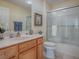 Small bathroom with tub, shower, and wood cabinets at 16841 Se 84Th Colerain Cir, The Villages, FL 32162