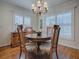 Elegant dining room showcasing a round table and four chairs, hardwood floors, and plantation shutters at 16841 Se 84Th Colerain Cir, The Villages, FL 32162