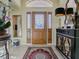 Bright and airy entryway with a wooden door and decorative rug at 16841 Se 84Th Colerain Cir, The Villages, FL 32162