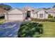 Attractive one-story home with a blue door and well-manicured lawn at 16841 Se 84Th Colerain Cir, The Villages, FL 32162