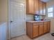 Bright laundry room with wood cabinets and ample counter space at 16841 Se 84Th Colerain Cir, The Villages, FL 32162