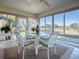 Sunroom with glass windows, wicker dining set, and golf course view at 16841 Se 84Th Colerain Cir, The Villages, FL 32162