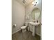 Powder room with pedestal sink, toilet, and a large mirror at 16929 Tesla Aly, Winter Garden, FL 34787