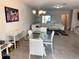 Bright dining area with glass table, white chairs, and modern chandelier at 16929 Tesla Aly, Winter Garden, FL 34787