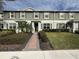 Two-story townhome with a landscaped front yard and brick walkway at 16929 Tesla Aly, Winter Garden, FL 34787