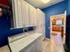 Bright laundry room with white cabinets and kitchen access at 17483 Se 74Th Netherclift Ter, The Villages, FL 32162