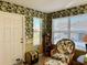 Relaxing sunroom with wicker furniture and leafy wallpaper at 17483 Se 74Th Netherclift Ter, The Villages, FL 32162