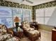 Bright sunroom featuring wicker chairs and tropical decor at 17483 Se 74Th Netherclift Ter, The Villages, FL 32162