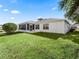 Spacious backyard with grassy lawn and screened patio at 2001 Cordero Ct, The Villages, FL 32159