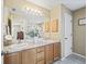 Double vanity bathroom with light wood cabinets and a large mirror at 2001 Cordero Ct, The Villages, FL 32159