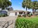 Single story house with a two-car garage and mature landscaping at 2001 Cordero Ct, The Villages, FL 32159