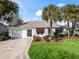 House with palm trees, landscaped yard and driveway at 2001 Cordero Ct, The Villages, FL 32159