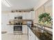 Modern kitchen with white cabinets, granite counters, and stainless steel appliances at 2001 Cordero Ct, The Villages, FL 32159