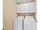 Convenient laundry room with washer, dryer, and overhead cabinets at 2001 Cordero Ct, The Villages, FL 32159