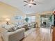 Bright living room with hardwood floors, comfy sofas, and access to a screened porch at 2001 Cordero Ct, The Villages, FL 32159