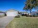 Single story home exterior with a two car garage and well kept lawn at 2009 Claudio Ln, The Villages, FL 32159