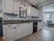 Kitchen with white cabinets, granite countertops, and black dishwasher at 2009 Claudio Ln, The Villages, FL 32159