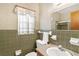 Bathroom with olive green tile, single sink vanity, and shower at 2010 Hollywood Dr, Leesburg, FL 34748