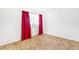 Bright bedroom with neutral carpeting and red curtains at 2010 Hollywood Dr, Leesburg, FL 34748