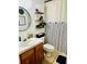 Clean bathroom featuring a striped shower curtain and wooden vanity at 204 Lori Ct, Umatilla, FL 32784