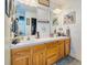 Double vanity bathroom with wood cabinets and a large mirror at 204 Lori Ct, Umatilla, FL 32784