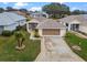 Aerial view of a single-story house with a two-car garage and landscaped yard at 21122 Lionheart Dr, Leesburg, FL 34748