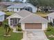 Single-story house with a two-car garage and well-maintained lawn at 21122 Lionheart Dr, Leesburg, FL 34748