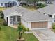 Single story house with a two-car garage and landscaped yard at 21122 Lionheart Dr, Leesburg, FL 34748