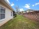 Landscaped backyard with grassy area and retaining wall at 21122 Lionheart Dr, Leesburg, FL 34748