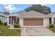 Front view of a single story house with a two-car garage at 21122 Lionheart Dr, Leesburg, FL 34748