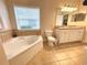 Bathroom with a large soaking tub, double vanity, and tile flooring at 2185 Victoria Dr, Davenport, FL 33837