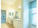 Bathroom features a double vanity with mirrors and a glass enclosed shower at 2202 Margarita Dr, The Villages, FL 32159