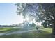 Picturesque community view showcasing a lush green golf course, mature trees, and a walking path at 2202 Margarita Dr, The Villages, FL 32159