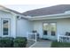 Inviting entrance with double glass doors and charming seating area at 2202 Margarita Dr, The Villages, FL 32159