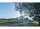 Scenic view of the golf course with trees and walking path under a bright blue sky at 2202 Margarita Dr, The Villages, FL 32159