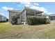 House exterior showcasing a screened patio and well-maintained landscaping at 3257 Kilarny Pl, The Villages, FL 32163