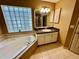 Bathroom with corner tub, vanity, and tile flooring at 33304 Kaylee Way, Leesburg, FL 34788