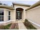 Front entrance with arched entryway and decorative glass door at 33304 Kaylee Way, Leesburg, FL 34788