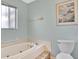 Bathroom with a bathtub, toilet and window at 33352 Fountain Ln, Leesburg, FL 34788