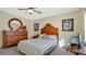 Second bedroom with a queen-size bed and wood dresser at 33352 Fountain Ln, Leesburg, FL 34788