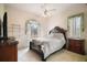 Comfortable bedroom with a ceiling fan, large windows, and ample closet space at 34245 Rosa Ln, Fruitland Park, FL 34731