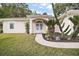 Front entry with a decorative archway and lush landscaping at 34245 Rosa Ln, Fruitland Park, FL 34731