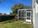 Backyard view of the home with a screened porch and lush green grass at 3570 Rollingbrook St, Clermont, FL 34711