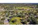 Aerial view of a community with houses, golf course, and lush green landscape at 3898 Beacon Ridge Way, Clermont, FL 34711