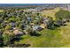 Aerial view of houses and a golf course community near a lake at 3898 Beacon Ridge Way, Clermont, FL 34711