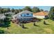 Backyard view of two-story house with a screened pool and spacious grassy area at 3898 Beacon Ridge Way, Clermont, FL 34711