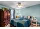 Bedroom with a queen bed, wooden armoire, and light blue walls at 3898 Beacon Ridge Way, Clermont, FL 34711